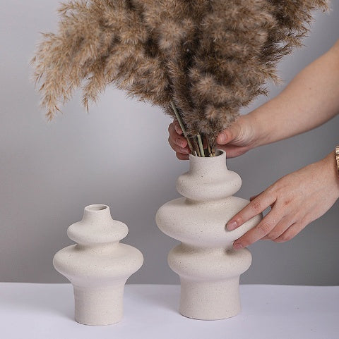 Hand styling modern ceramic vase with dried stems, minimalist white home décor piece by Lunari Haus.