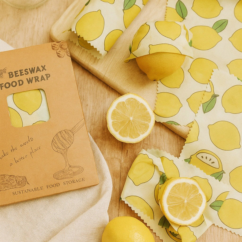 Beeswax food wrap with lemon pattern on a wooden surface with lemons.