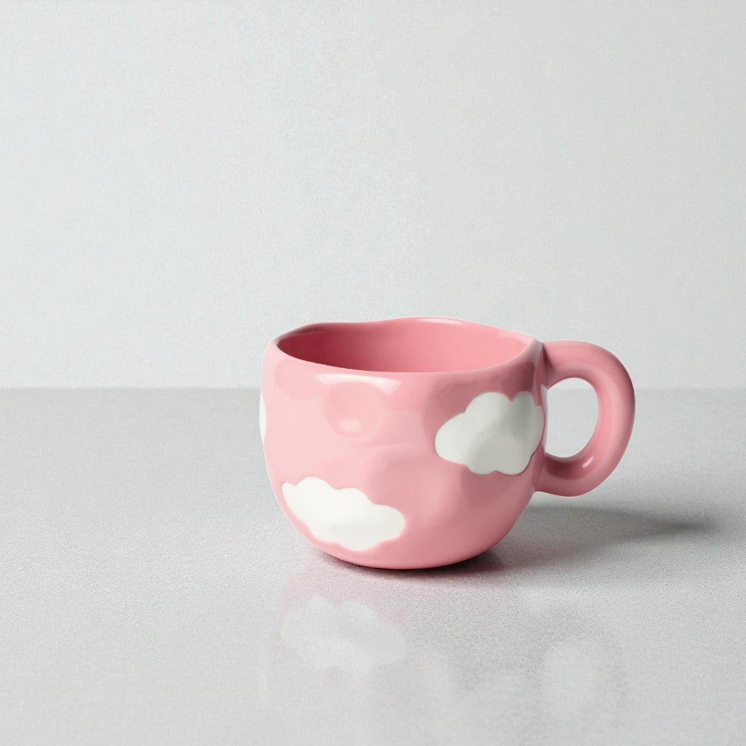 Pink mug with cloud designs on a light gray background