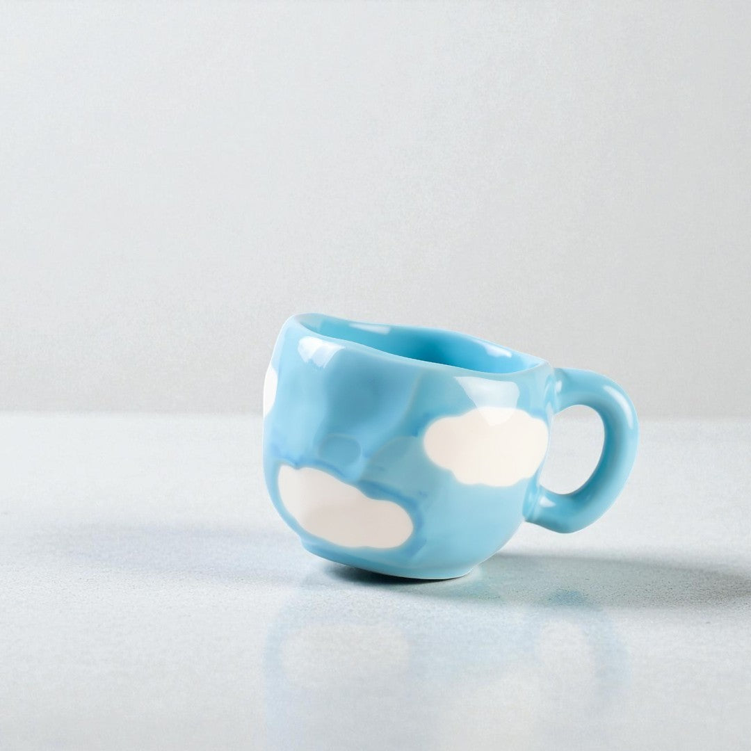 Blue mug with white cloud designs on a light gray background